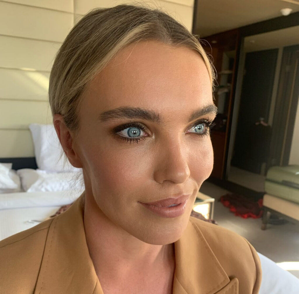 A businesswoman has her hair and makeup done in a hotel setting