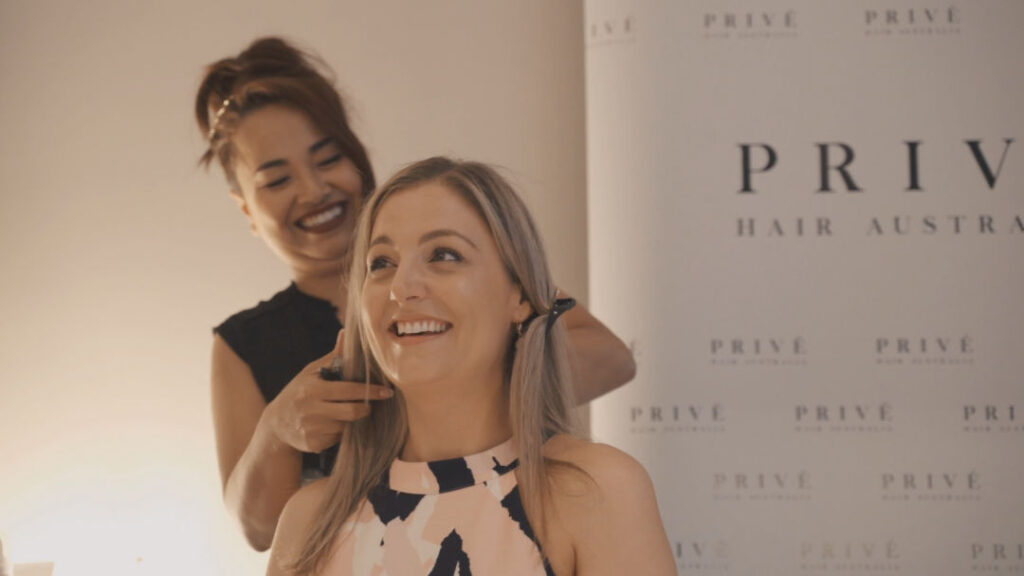 A woman smiling and enjoying herself during her hair and makeup session