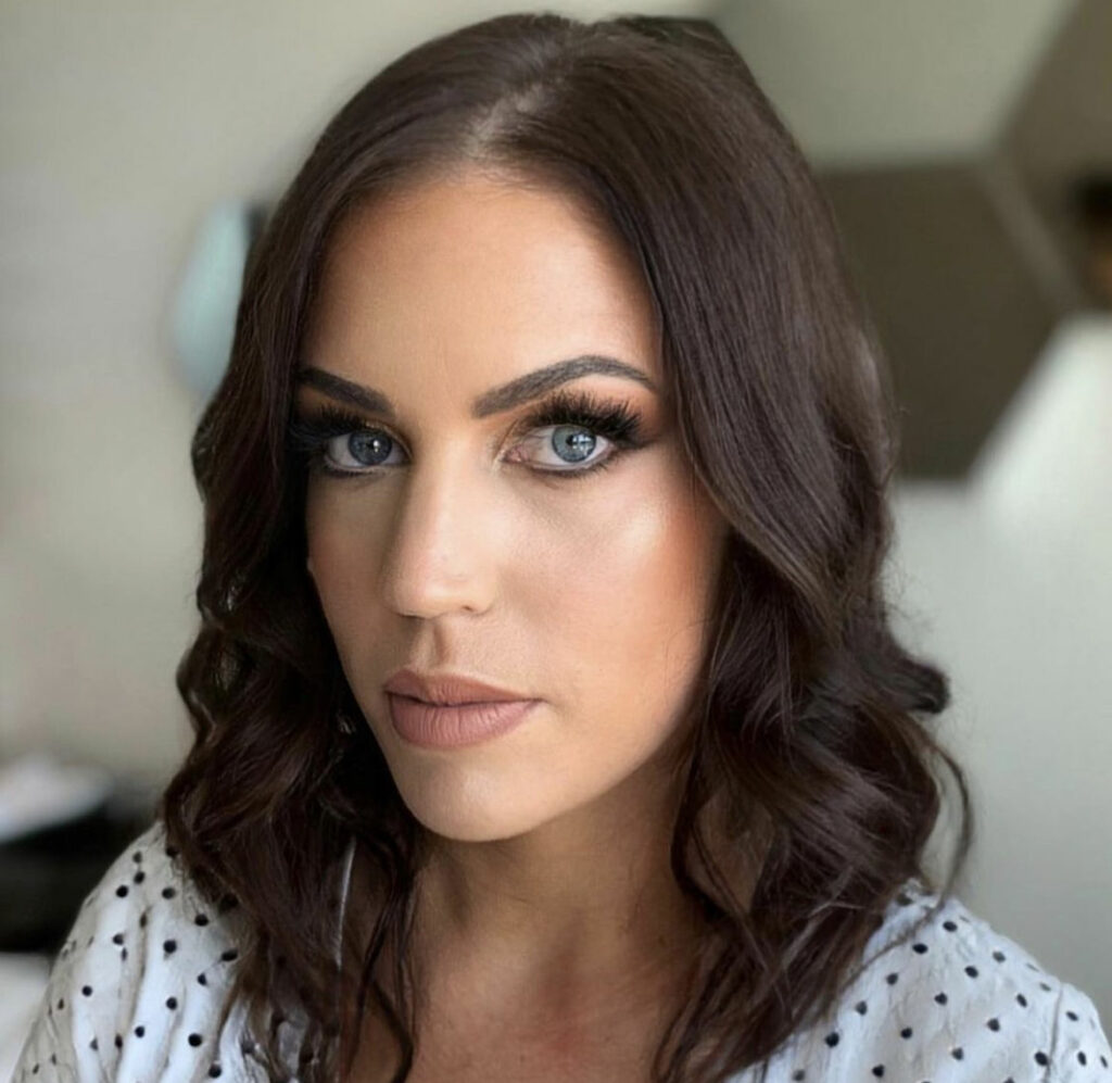 A head and shoulders image of a beautiful model with stunning styled dark hair and makeup